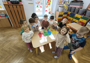 Dzieci stoją razem przy stoliku.