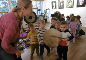 Chłopiec uderza pałką w bębenek.