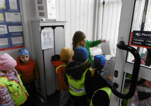 Nauczycielka stoi przy oknie na poczcie.