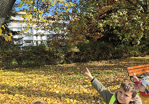 Chłopiec palcem wskazuje na budkę dla ptaków.