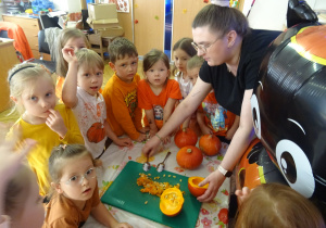 Nauczycielka podczas krojenia dyni.