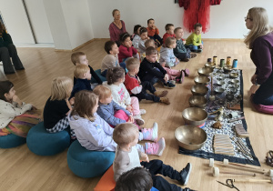 Dzieci siedzą na podłodze podczas warsztatów.