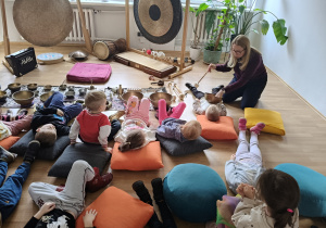 Dzieci leżą na kolorowych poduszkach.