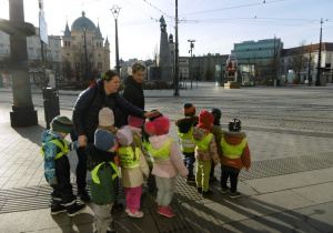 Grupa dzieci stoi przy ulicy.