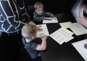 Dwóch chłopców siedzi przy stole.