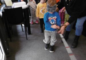 Chłopiec idzie z laską przez salę.