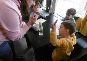 Chłopiec podnosi rękę do góry.