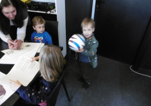 Chłopiec trzyma w ręku piłkę.