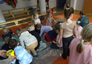 Dzieci zbierają kolorowe kulki.