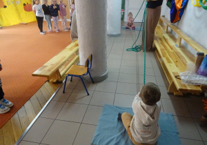 Dzieci trzymają linę z obu stron.