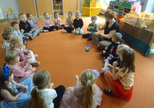 Dzieci siedzą w kole.