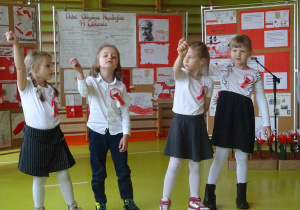 Czwórka dzieci stoi na środku i wykonuje pieśń patriotyczną