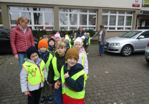 Grupa dzieci wychodzi ze szkoły.