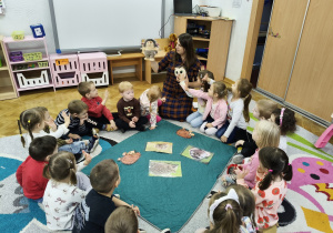 Dzieci siedzą w kole.