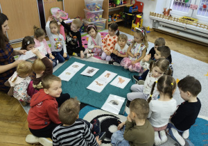 Dzieci siedzą na dywanie.