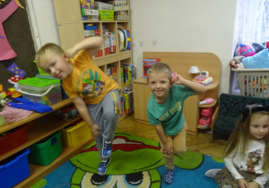 Dzieci stoją na jedej nodze.