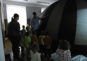 Grupa dzieci szykuje się do wejścia do namiotu.