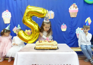 Dziewczynka dmuch świeczkę.