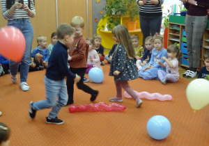 Dzieci biegają wokół balonów.