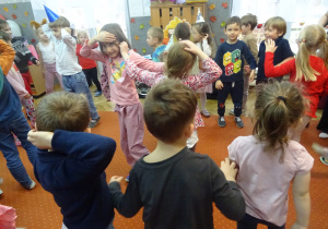 Dzieci podczas wspołnych tańców na dywanie.