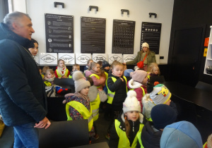 Dzieci podczas warsztatów stoją w sali.