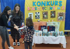 Nauczycielki wręczają nagrody dziecku.