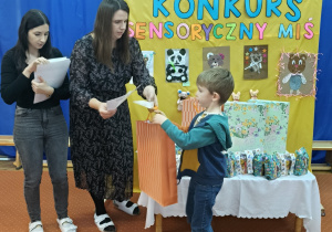 Nauczycielki wręczają nagrody innemu dziecku.