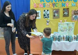 Nauczycielki wręczają nagrody innemu dziecku.