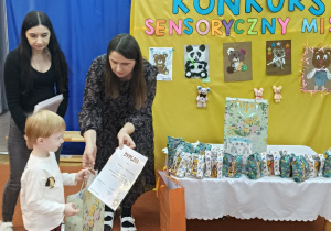 Nauczycielki wręczają nagrody innemu dziecku.