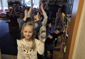 Dziewczynka trzyma but w ręku.