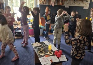 Dzieci trzymają ręce w górze.