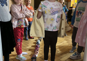 Dziewczynka stoi przy butach ustawionych jeden za drugim.