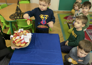 Chłopiec wyjmuje ciastko z wróżbą.