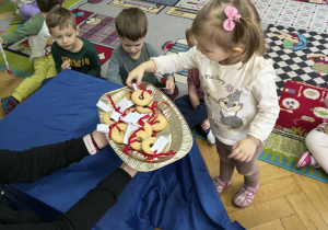 Dziewczynka trzyma w ręku ciastko z wróżbą.