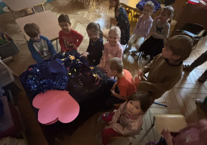 Dzieci siedzą wokół stolika.