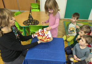 Dziewczynka losuje ciastko z wróżbą.