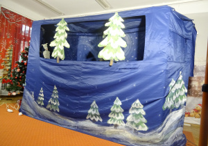 Dwie białe choinki stoją na scenie.