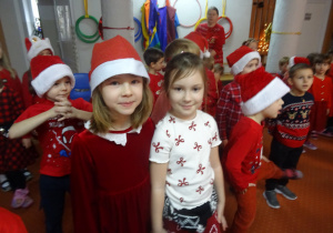 Grupa dzieci stoi przed Mikołajem.