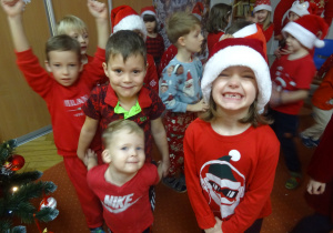 Inna grupa dzieci stoi przed Mikołajem.