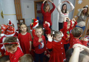 Nauczyciele i dzieci tańczą z Mikołajem.
