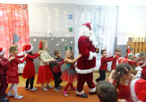 Mikołaj tańczy razem z dziećmi.