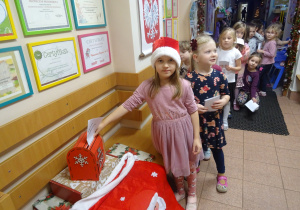 Dziewczynka wrzuca list do skrzynki.