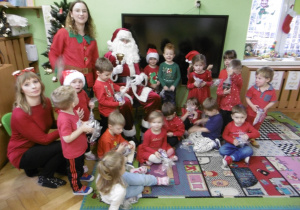 Elf i Mikołaj stoją razem obok siebie.