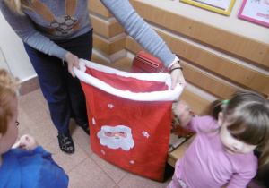 Nauczyciel trzyma czerwony worek na listy.