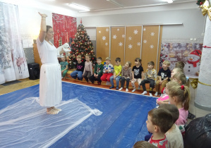 Osoba prowadząca warsztaty stoi przed dziećmi.