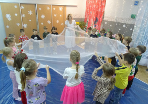 Dzieci trzymają przed sobą białą chustę.