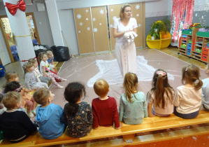 Osoba prowadząca stoi przed dziećmi.