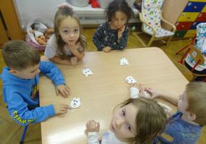 Grupa dzieci siedzi przy stoliku.