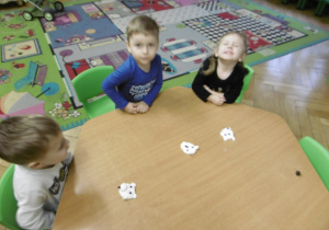 Inna grupa dzieci siedzi przy stoliku.