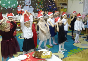 Dzieci występują przy świątecznym stole.